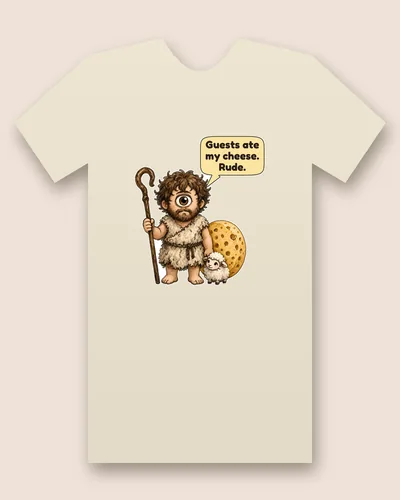 Polyphemus tee mockup: A shaggy one-eyed giant shepherd in a rough fleece tunic holding a tall crooked staff, beside a round wheel of cheese and a small lamb, with a speech bubble above him, saying “Guests ate my cheese. Rude.”