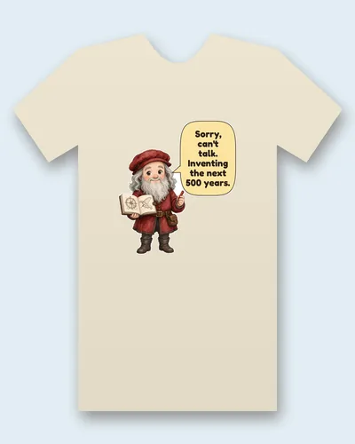 Leonardo da Vinci tee mockup: Leonardo da Vinci with a long white beard, in a red cap and tunic, holding a sketchbook full of gear and wing drawings, saying “Sorry, can't talk. Inventing the next 500 years.”