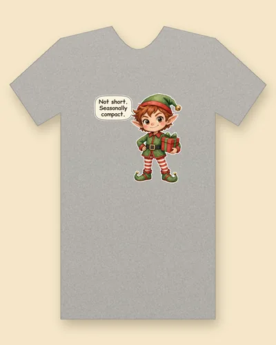 Christmas Elf tee mockup: a red-haired elf in a green hat and tunic with red-and-white striped stockings and curled shoes, holding a wrapped gift, saying “Not short. Seasonally compact.”