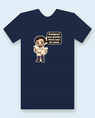 Alphonse Mucha tee mockup: Alphonse Mucha with swept-back dark hair and a pointed beard, in a belted cream embroidered tunic, holding a drawing pencil and a blank sheet of paper, saying “Designed one poster. Paris lost its mind.”