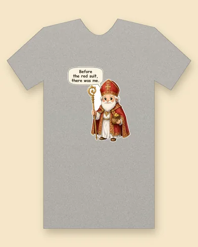 Saint Nicholas tee mockup: Saint Nicholas with a white beard in a red bishop's mitre and red and gold robes, holding a gold staff and a small bag of gold, saying “Before the red suit, there was me.”
